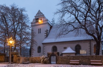 Old church with illuminated poinsettia, snowy and at dusk, Coswig, Saxony, Germany, Europe