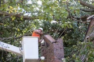 Detroit, Michigan, A worker dismantles a brick chimney after a storm with 70mph wind gusts blew