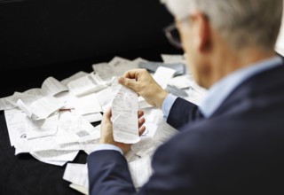 The subject of taxes. A man holds receipts in his hand in Berlin, 09/08/2024