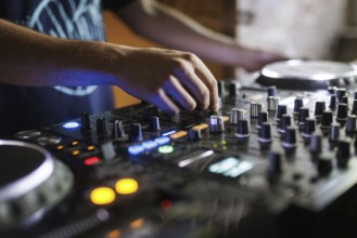 A DJ plays on a mixer and two Cdjs in Berlin, 14/08/2024