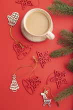 Christmas or New Year composition. Decorations, fir and spruce branches, cup of coffee, on a red