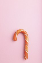 Single cane candy on pink pastel background. copy space, top view, flat lay