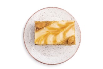 Honey cake with milk cream, caramel, almonds isolated on a white background. Top view, flat lay,