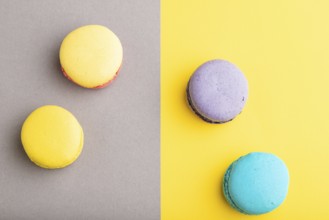 Yellow, purple and blue macaroons on trendy gray and yellow background. top view, copy space, close