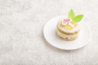 Decorated cake with milk and coconut cream on a gray concrete background. Side view, copy space,