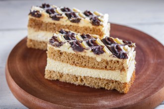 A piece of cake with milk and butter cream on a wooden kitchen board, close up, selective focus,