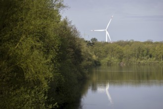 Behind a lake near Münster, there is a wind turbine. 08.04.2024