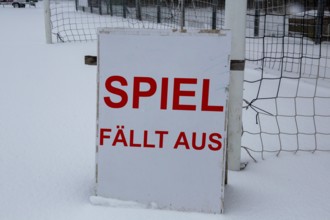 Symbolic image of a football match cancelled due to snow. Sign on a sports field with the