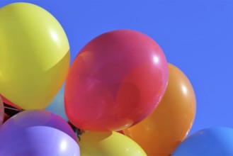 Close-up of colourful balloons against a blue sky