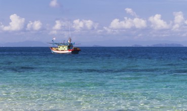 Blue sea and a small fishing boat. Malaysia