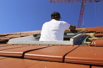 Employees of Zimmerei Mellein GmbH install the roof windows in the Mutterstadt development area,