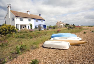 Boats and house on beach, Shingle Street, Suffolk, England, UK