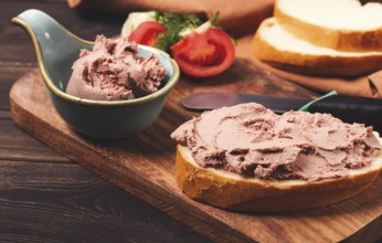 Liver meat pate spread, on white bread, on a wooden background, breakfast, close-up, no people,