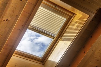 Interior view of a skylight with electronic blinds on a ceiling with wooden panelling