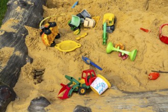 Sandpit, on a children's playground, sandpit with various plastic toys, excavator, shovels, moulds