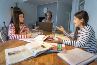 Homeschooling, during the lockdown in January 2021, children learn at home for school, their mum is