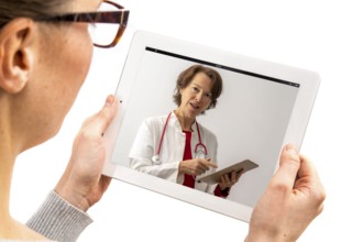 Symbolic image of telemedicine, patient speaking to a doctor in a video conference from home