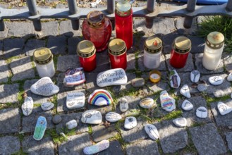 Candles and stones with inscriptions in memory of the dead of the corona pandemic, stickers from