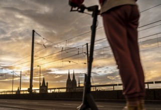 Skyline with Cologne Cathedral, Gross St. Martin Catholic Church, Deutz Bridge, sunset, e-scooter