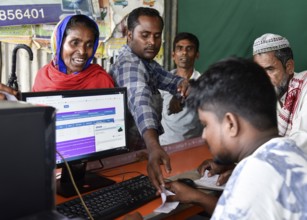 People checks their names in a roadside DTP centre, in the published final list of National