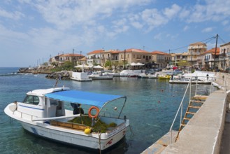 Quiet harbour with boats and surrounding buildings under a blue sky, Agios Nikolaos, Mani,