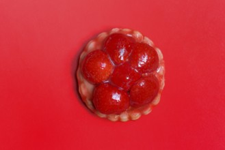 Strawberry tartlets on a red background, fruit cake