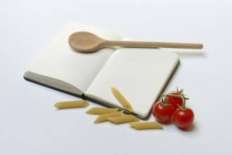 Notebook for recipes, cooking spoons, pasta and tomatoes