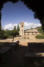 Ornamental garden with mirror water basin and a tower on the Alhambra palace grounds, Granada,