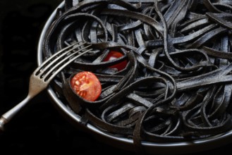 Black pasta coloured with squid ink on a plate, Taglioni al Nero di Seppia, Italy, Europe