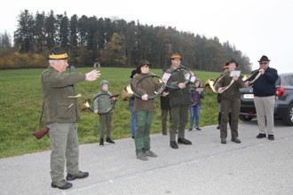 Hunting guide and hunting horn player in front of the start of the hunt for brown hare (Lepus