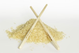 Rice (Oryza sativa), rice grains and chopsticks on a white background