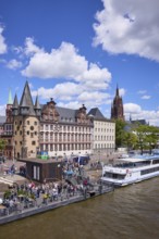 Saalhof with rent tower and excursion boats at the Mainkai under a blue sky with cumulus clouds in