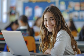 Happy teenager girl child learning with computer notebook in school classroom. Concept for modern