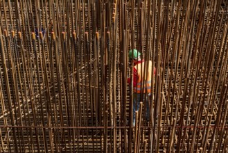 Construction site, reinforced concrete construction site, workers erect a mesh of reinforcing bars,