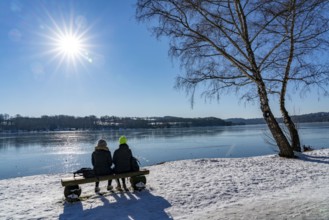 Winter in the Ruhr area, Lake Baldeney, snow-covered, partly frozen lake, walkers on the lakeside