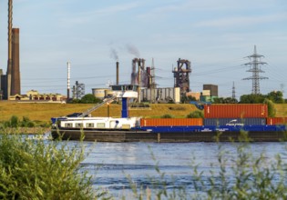 Industrial backdrop of the ThyssenKrupp Steel steelworks in Bruckhausen, on the Rhine, cargo ship,