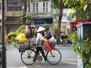 Vietnamese flower seller with conical hat and bicycle in the Old Quarter of Hanoi, Vietnam, Asia