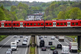 S-Bahn train crossing the motorway A3, traffic on 8 lanes, incl. the temporarily released hard