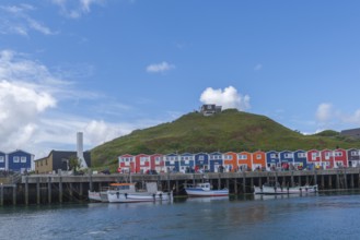 Colourful lobster shacks on the harbour promenade, Börteboote, offshore island Helgoland, blue sky,