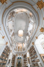 Old library with high ceilings, golden decorations and white walls that creates a calm atmosphere,