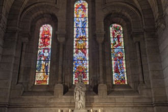 Stained glass windows illuminate a statue in a church, warm light floods in, Paris