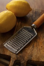 Lemons with a zest grater, on a chopping board, close-up, no people