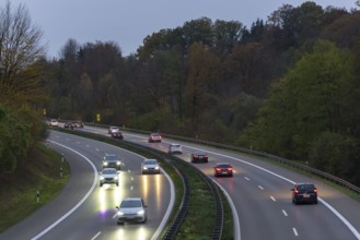 Traffic on a wet motorway at dusk, surrounded by trees, Rems-Murr district, Baden-Württemberg,