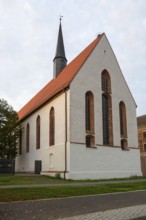 Gothic church with red tiled roof and high tower under a cloudy sky, St Augustin's Monastery