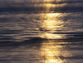 Abstract image of the North Sea, an early evening mood with colorful yellow reflections of the sun,