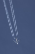 Boeing 747 jumbo jet cargo aircraft of UPS flying in a blue sky with a vapor trail or contrail