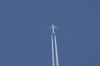 Boeing 737 jet passenger aircraft of Norwegian Air flying in a blue sky with a vapor trail or