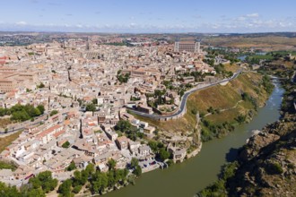 Aerial view of a historic city with many houses, a city wall and a river flowing through the city,