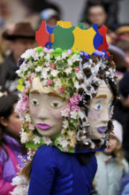 Person masked as a flower girl at the carnival parade of the Wey guild on Rose Monday, Güdismäntig,