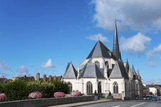 Gotische Kathedrale mit hohen Türmen und einem klaren Himmel mit Blumen im Vordergrund, Kirche,